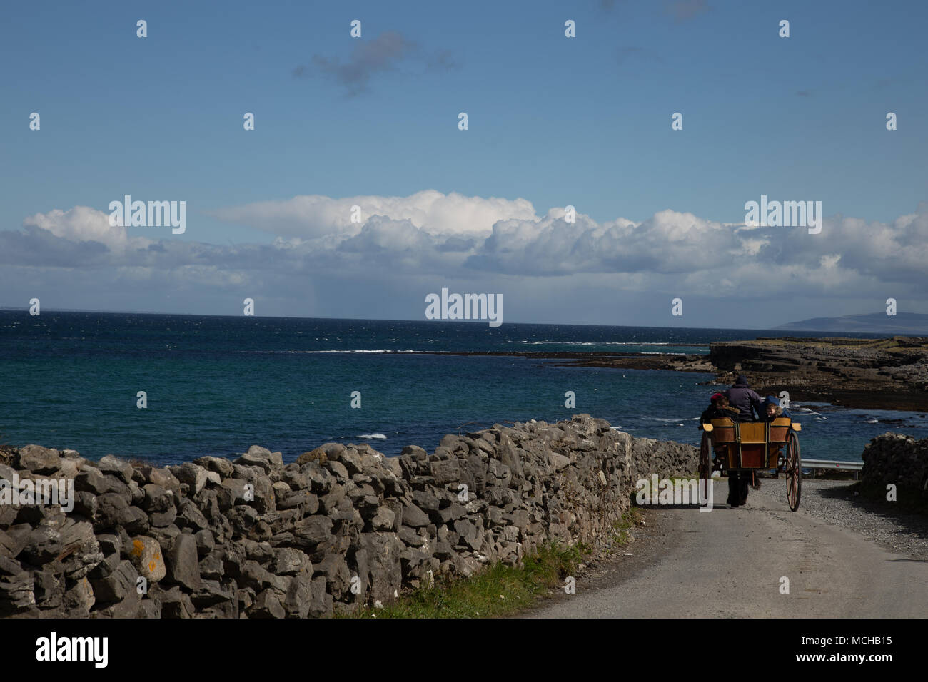 Les îles d'Aran, Irlande - touristes monter à cheval et piège à côté de l'océan Banque D'Images