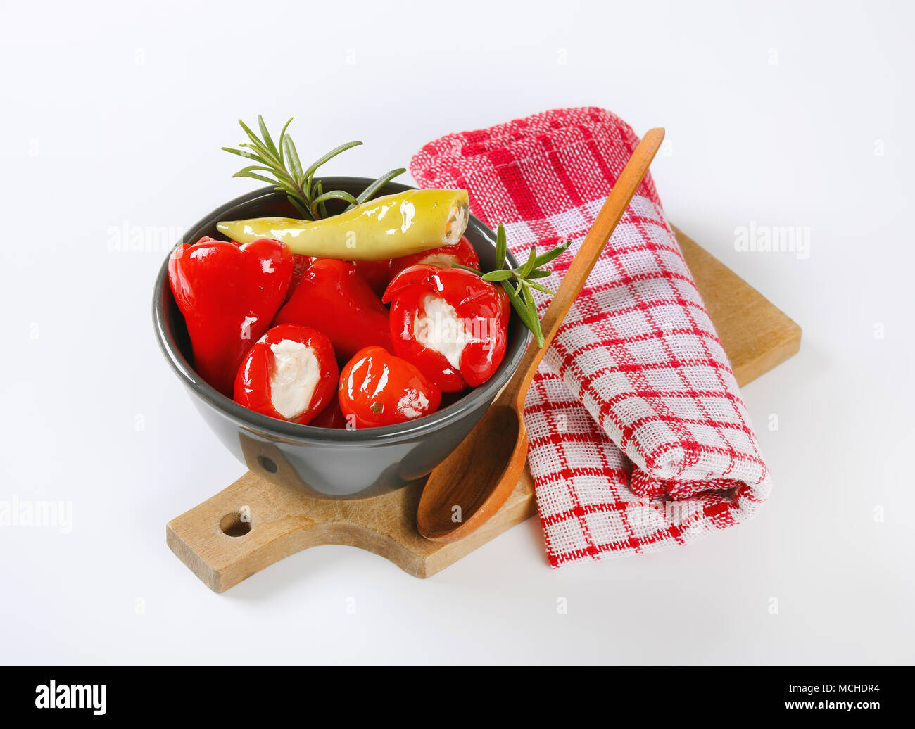 Bol de poivrons farcis au fromage sur la planche à découper en bois Banque D'Images Bol de poivrons farcis au fromage sur la planche à découper en bois Banque D'Images
