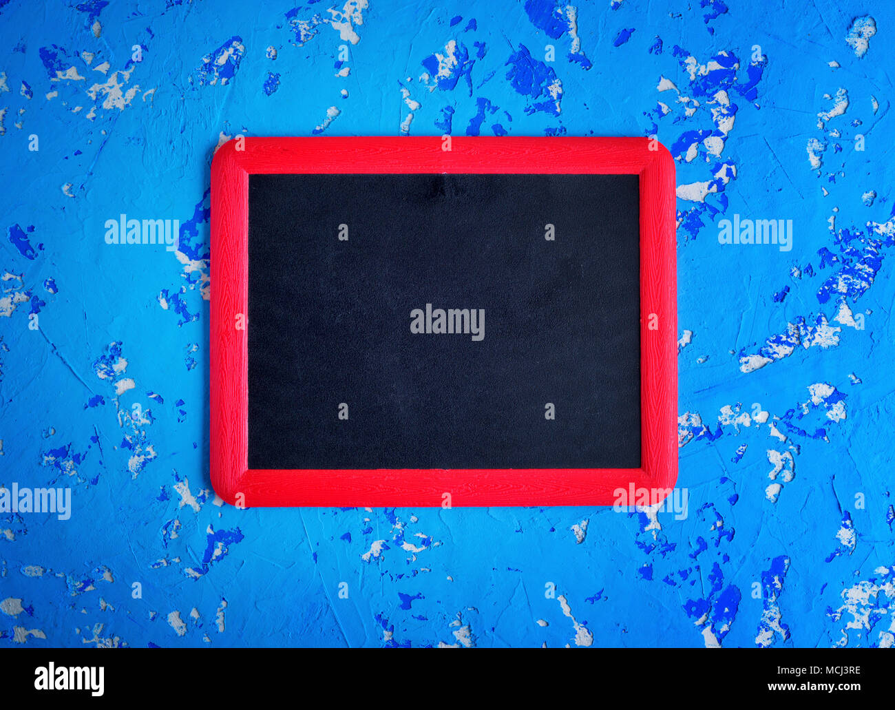 Craie noire vide conseil dans un cadre rouge sur une surface bleue usée, Close up Banque D'Images