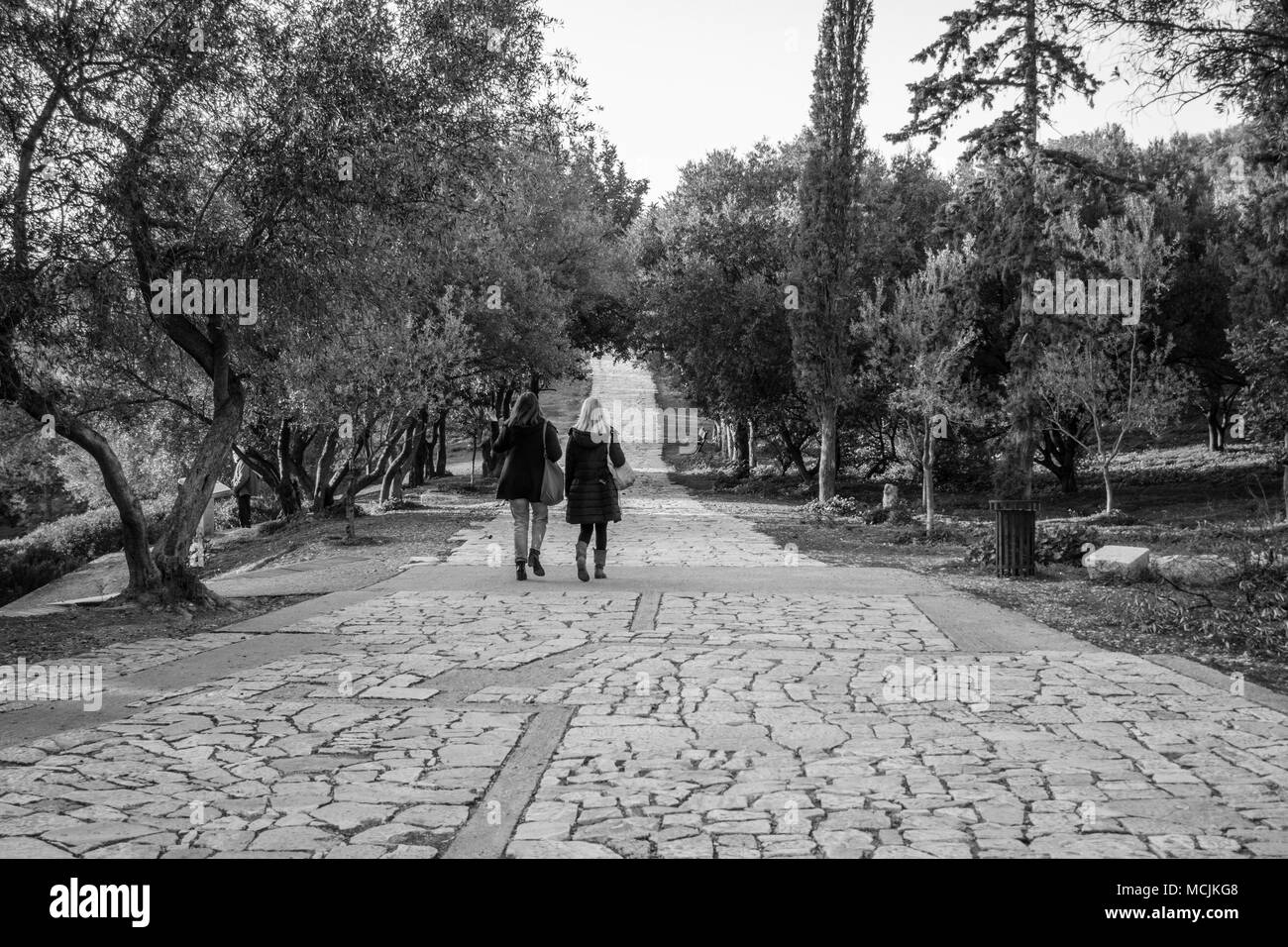 Vue arrière de deux jeunes femmes marchant sur passerelle piétonne, Athènes, Grèce Banque D'Images