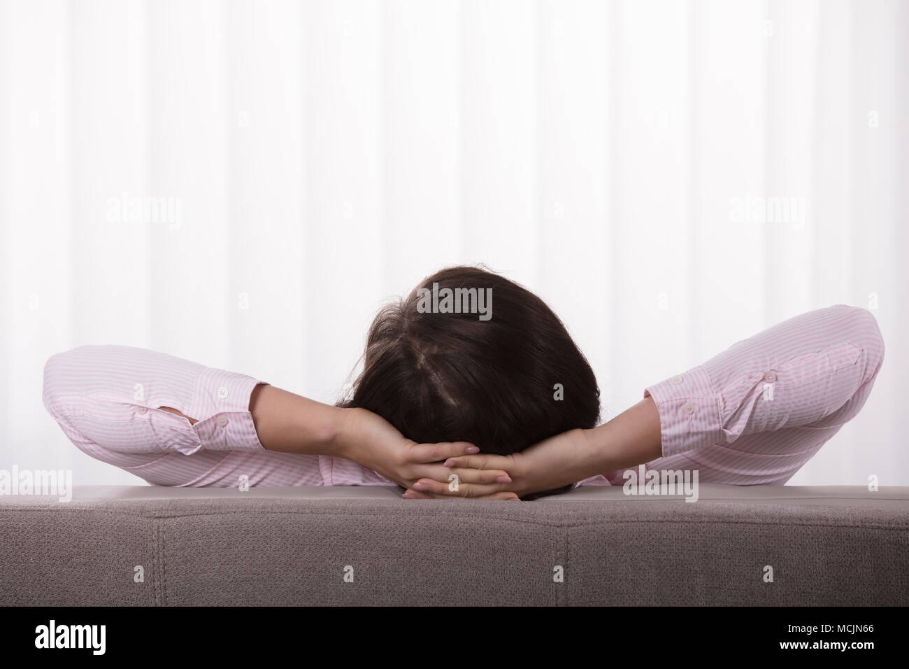 Close-up of a Woman On Sofa with Hand Behind Head Banque D'Images