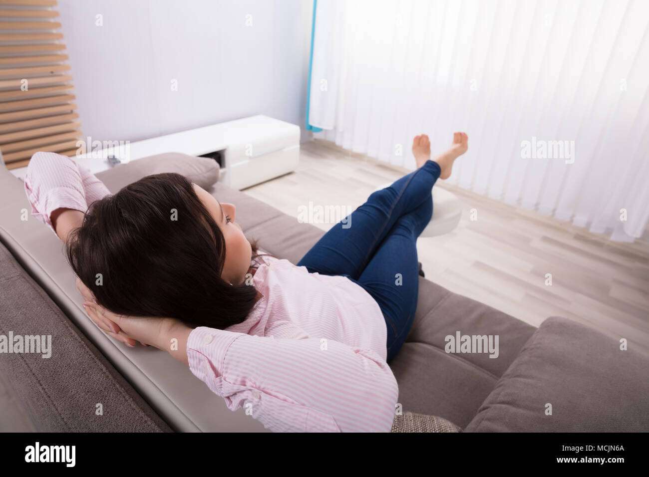 Close-up of a Woman On Sofa with Hand Behind Head Banque D'Images