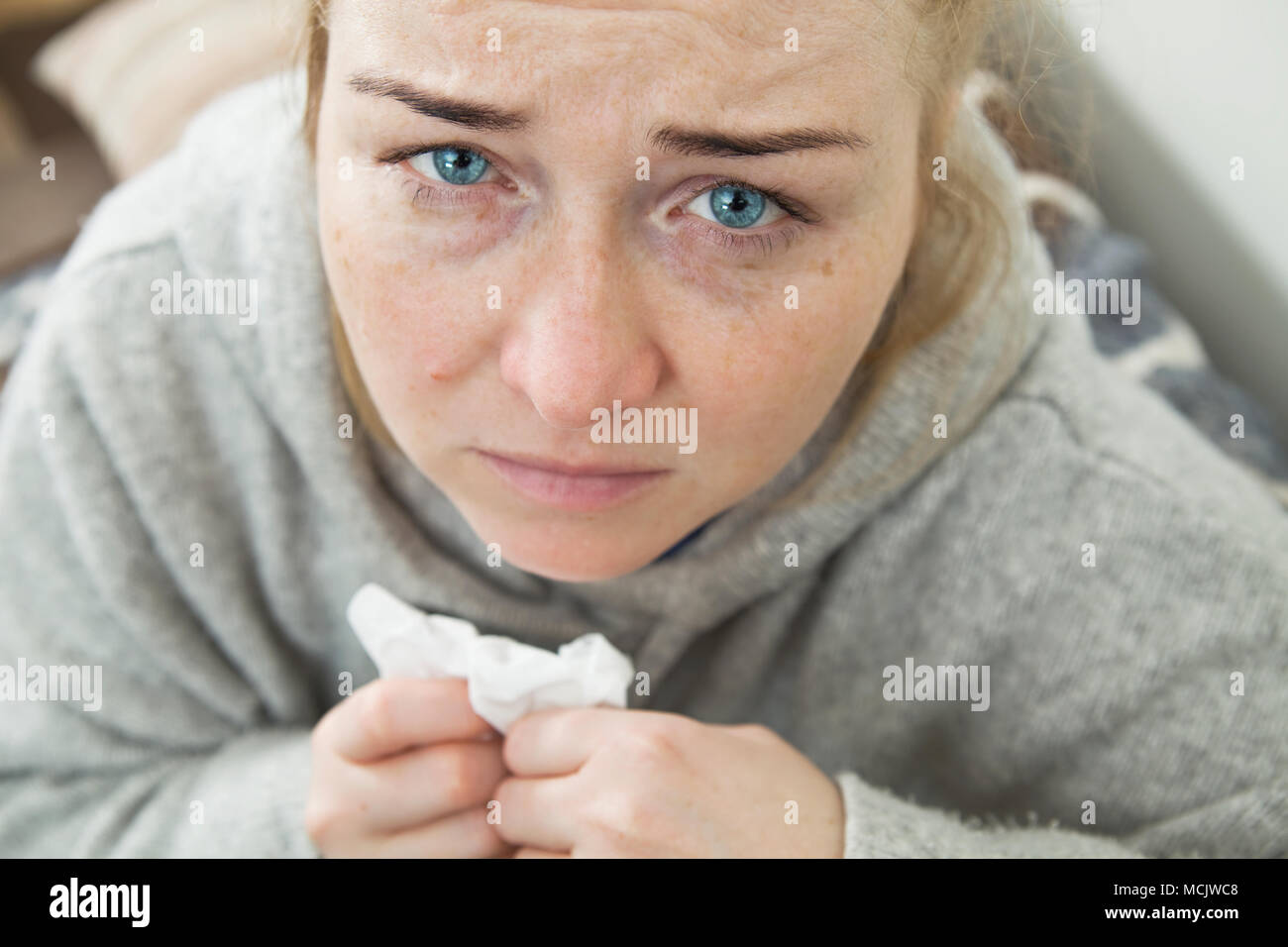 Malade et fatigué femme avec un mal de tête assis sur un canapé de demander de l'aide. Closeup portrait. Banque D'Images