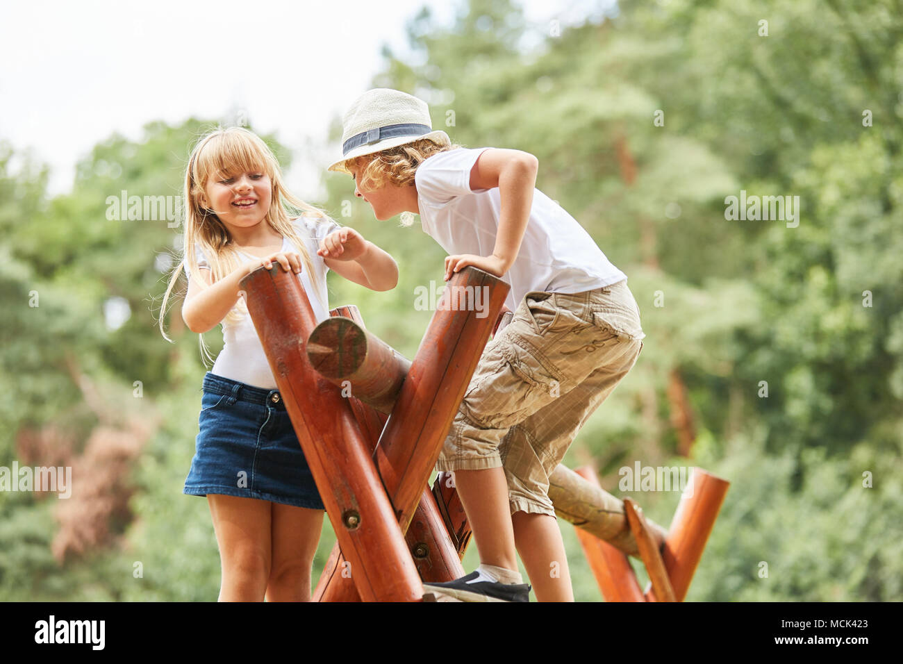 Frères et sœurs Les enfants s'amuser dans la jungle gym sur une aire de jeux Banque D'Images