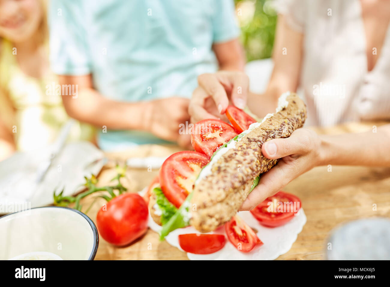 Ayant de la famille petit-déjeuner sain avec des tomates sur la baguette fraîche Banque D'Images