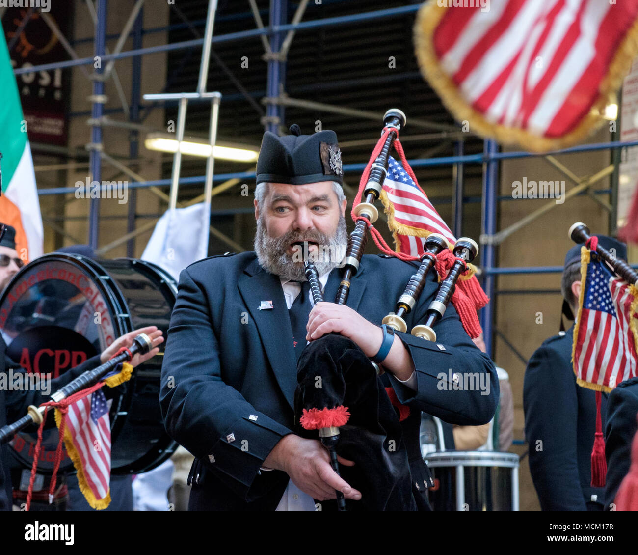 L'homme de l'American Celtic Pipe Band souffle cornemuses en marchant à St Patrick's Day Parade, New York City, 2018. Close up.American & drapeaux irlandais. Banque D'Images