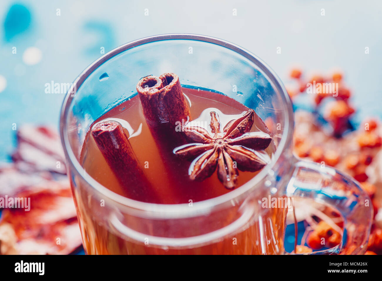 Tasse de thé à l'anis étoile et la cannelle close-up. Hors focus automne fond avec des feuilles et des baies. Rainy day concept avec copie espace. Banque D'Images