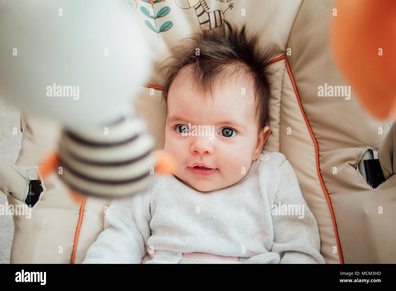 Portrait d'un bébé fille dans sa chaire de videur. Banque D'Images