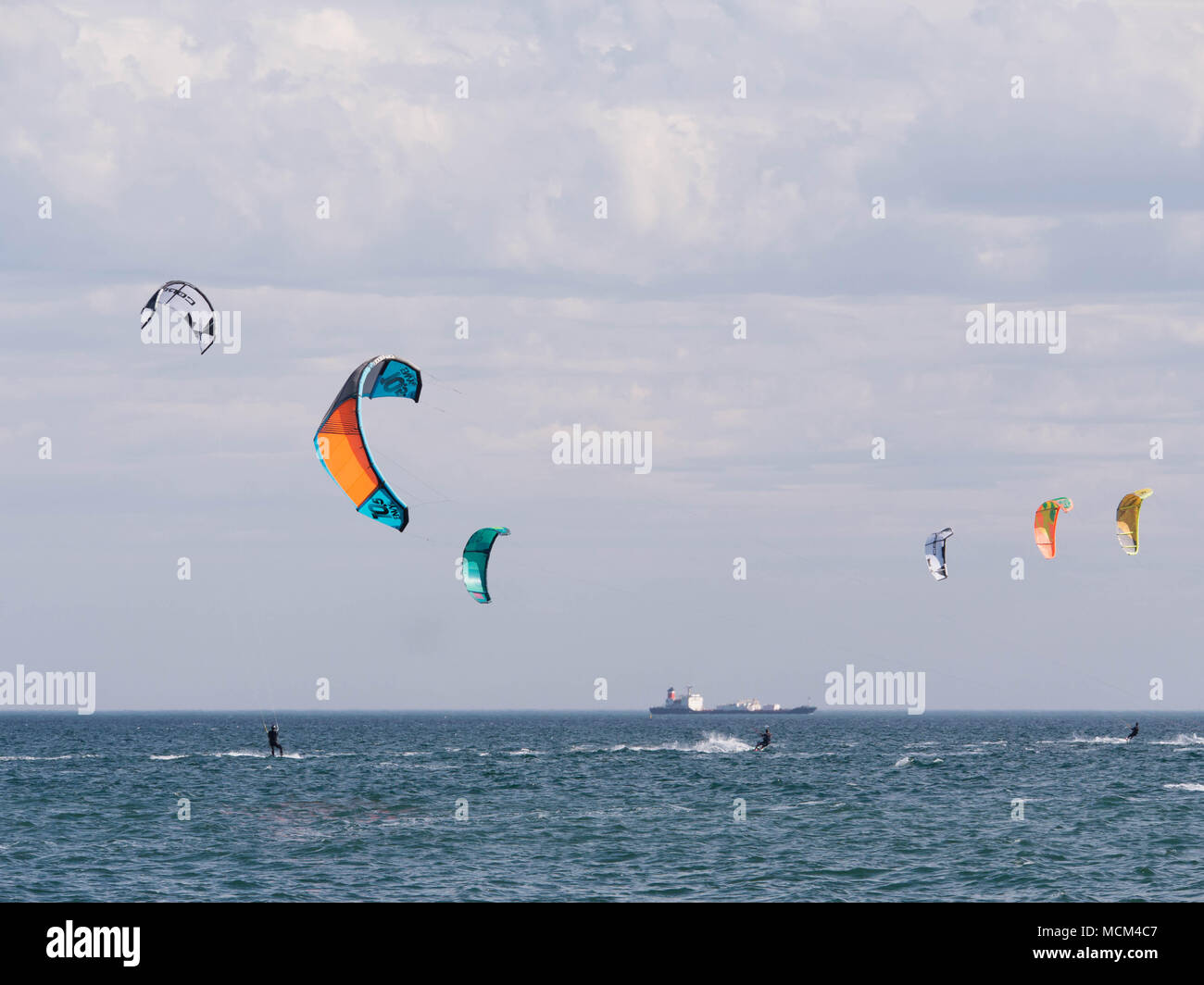 De nombreux kiteboarders multicolores sur l'horizon de la baie Port Phillip sur ciel bleu ensoleillé jour venteux excès à travers l'eau. Banque D'Images