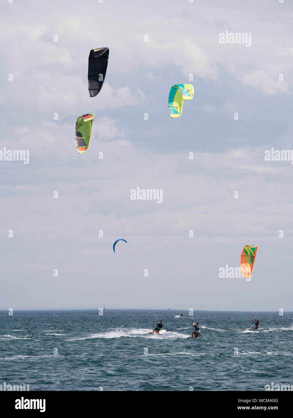 De nombreux kiteboarders multicolores sur l'horizon de la baie Port Phillip sur ciel bleu ensoleillé jour venteux excès à travers l'eau. Banque D'Images
