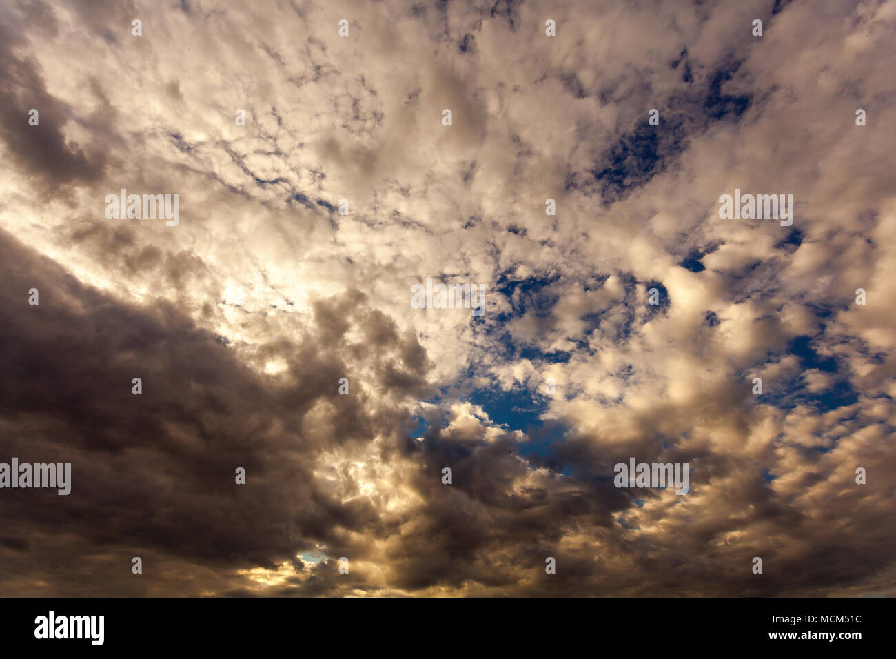 Blanc duveteux nuages sur ciel bleu au coucher du soleil Banque D'Images