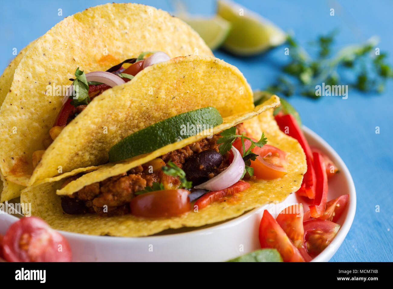 Tacos mexicains avec du boeuf haché et de légumes sur fond bleu rustique Banque D'Images