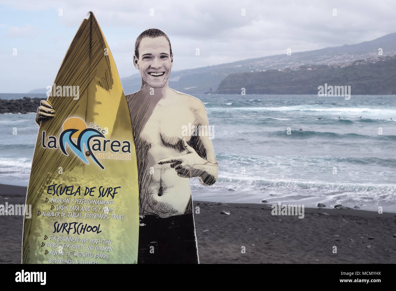 Puerto de la Cruz, Tenerife, Canaries ; une école de surf signe sur une des plages de sable noir faite à partir de la roche volcanique de l'île. Banque D'Images
