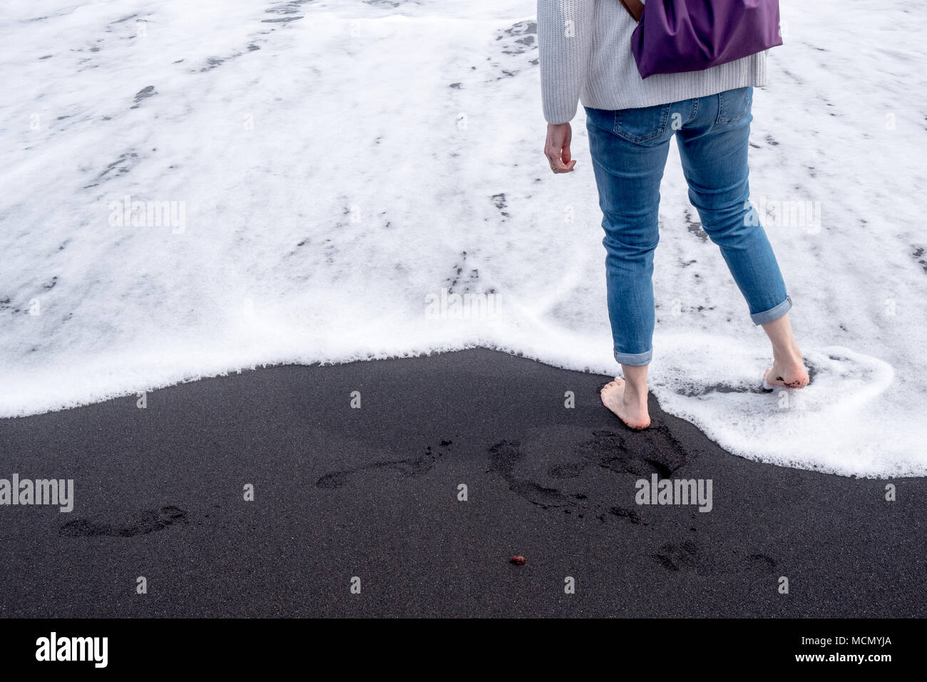 Puerto de la Cruz, Tenerife, Canaries, le tourisme ou les promenades sur le bord de l'eau comme des vagues sur la plage de sable volcanique noir. Banque D'Images