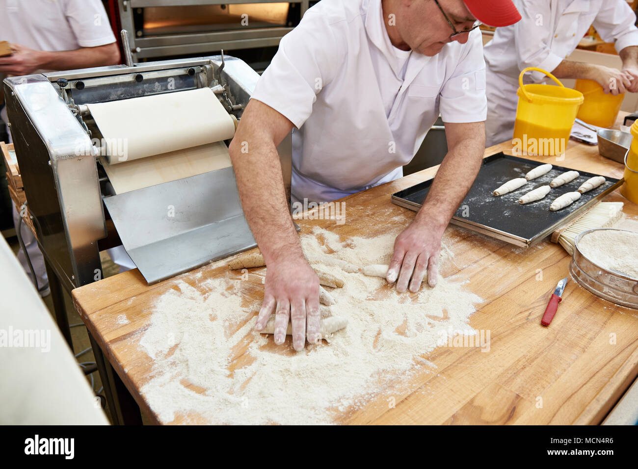 Les pâtissiers boulangers faire cuire la pâte pour rouler sur la table les pains de boulangerie Banque D'Images