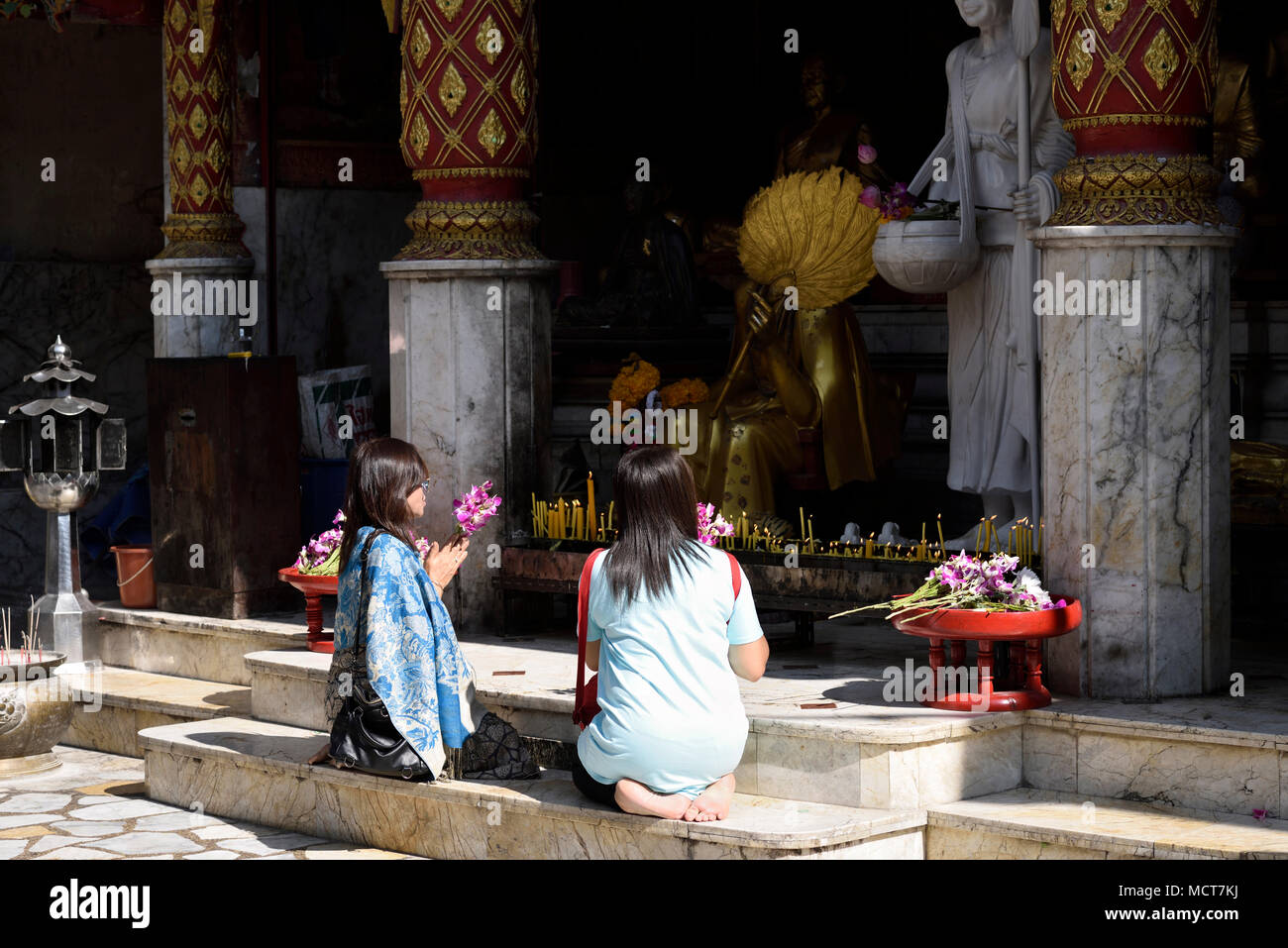 Deux femmes thaïlandaises en priant et en donnant des dons de fleurs au temple Wat Phrathat Doi Suthep Rajvoravihara, Chiang Mai, Thaïlande Banque D'Images