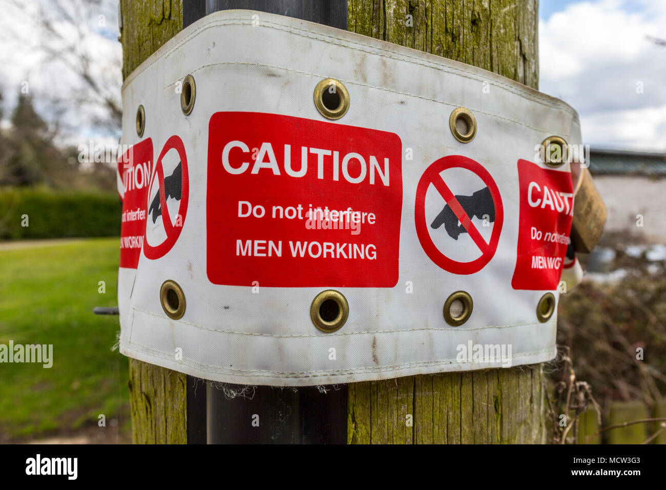 Les hommes travaillant à signer au poteau télégraphique. Suffolk, UK. Banque D'Images