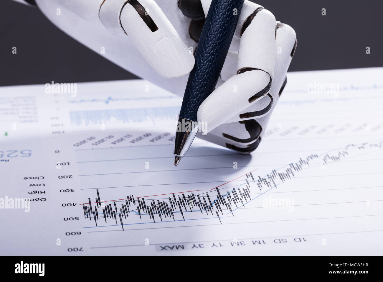 Portrait d'une main robotique tenir pen sur document financier Banque D'Images