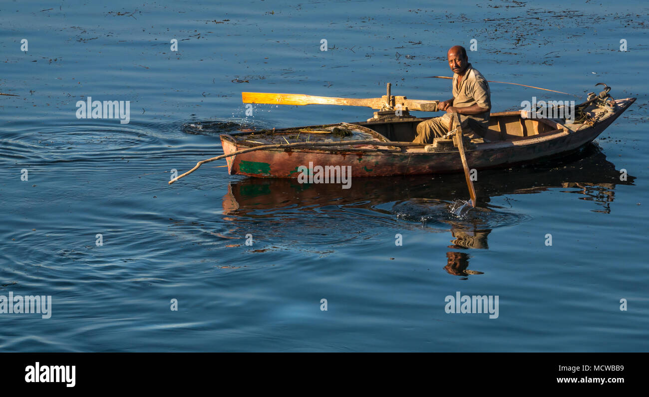 L'Homme égyptien en barque à la rame in early morning light, looking at  camera, avec de l'eau lisse réflexions, Nil, l'Egypte, l'Afrique Photo  Stock - Alamy