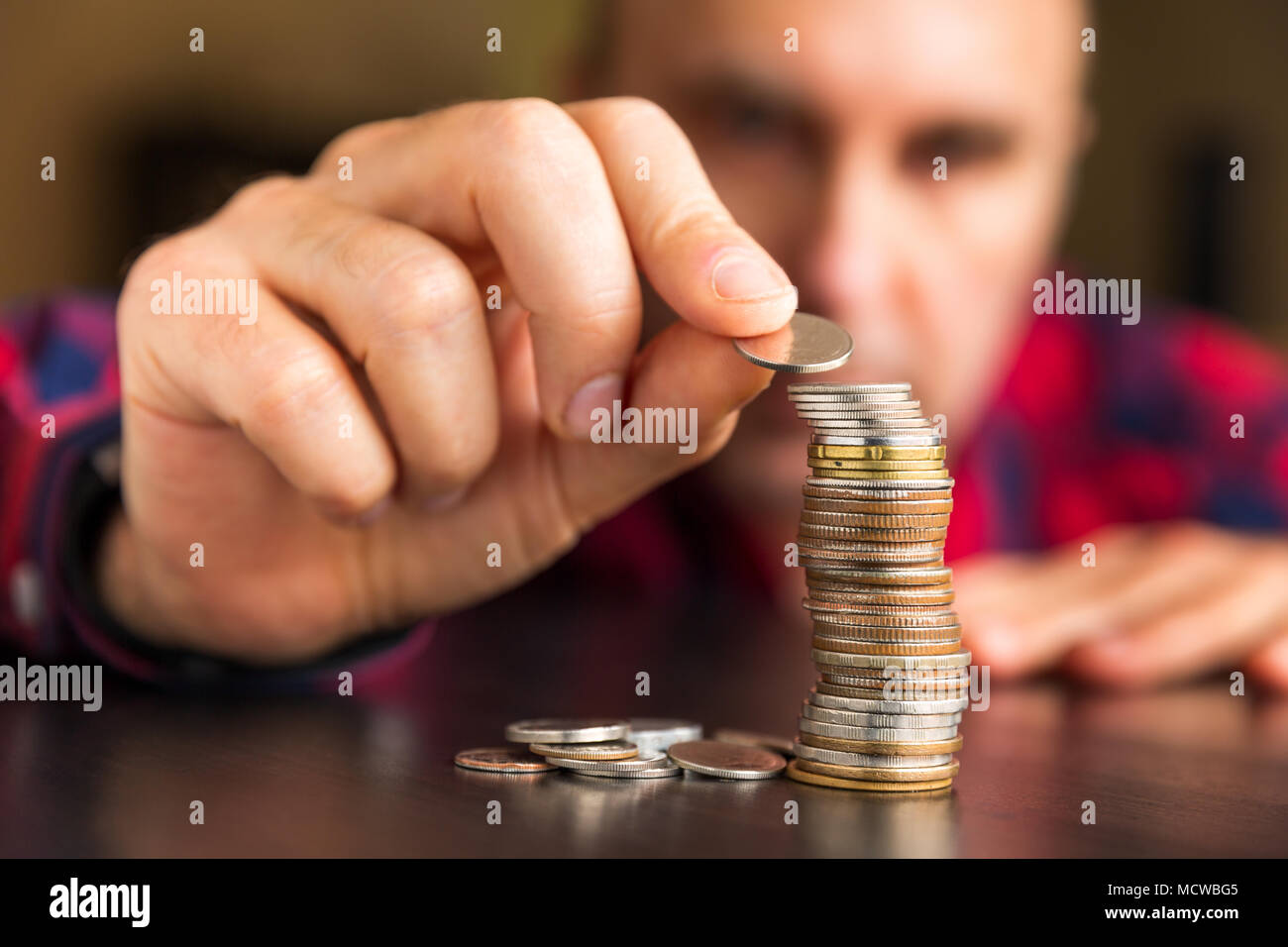 Homme non identifiables compte ses pièces de monnaie sur une table. Finances personnelles, gestion des finances, Thrifty ou l'avarice concept. Banque D'Images