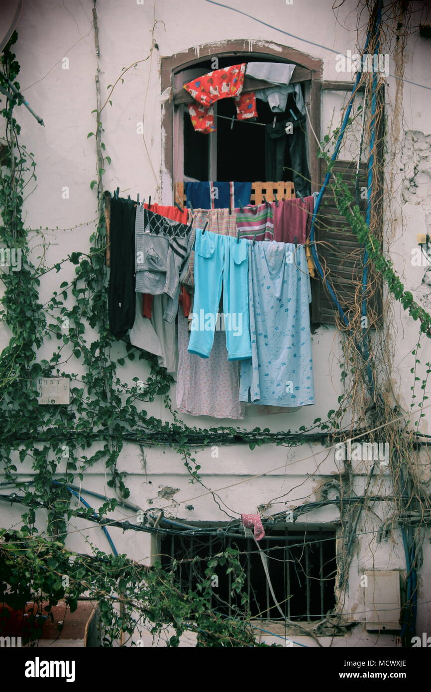Vieille photo de linge séchant sur une corde à linge à l'extérieur une fenêtre à Casablanca, Maroc Banque D'Images