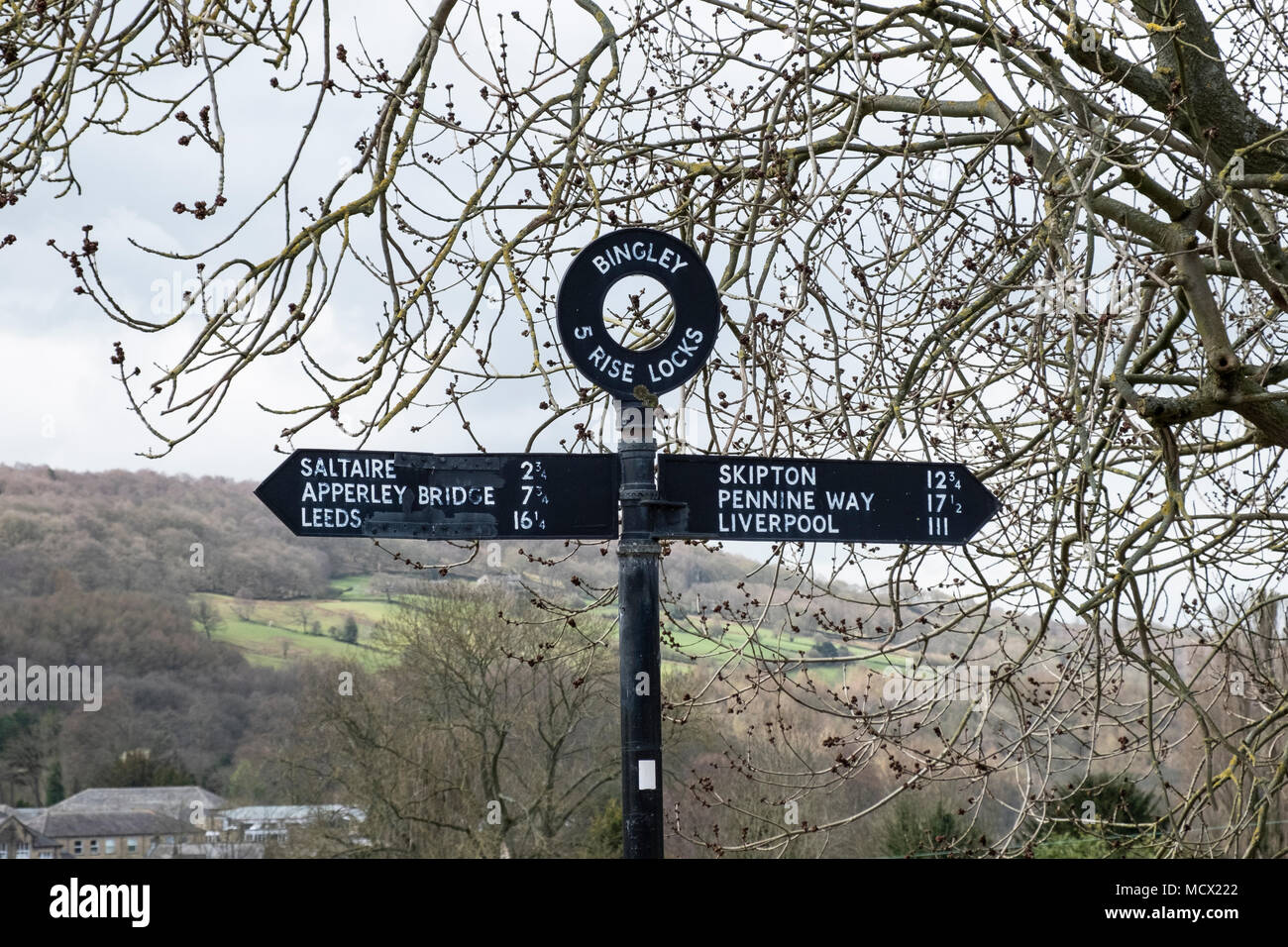 Un signpostThe direction montée cinq écluses sur le canal de Leeds et Liverpool, Bingley, près de Bradford, West Yorkshire, Angleterre. Banque D'Images