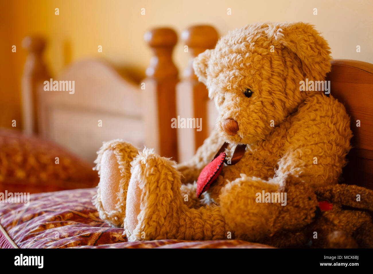 Triste face ours assis tout seul sur un lit. Représente la solitude et la dépression Banque D'Images