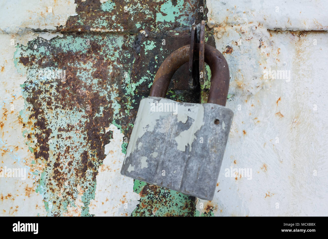 Ancien cadenas rouillé accroché sur grungy metal porte. La photo en gros plan avec selective focus Banque D'Images