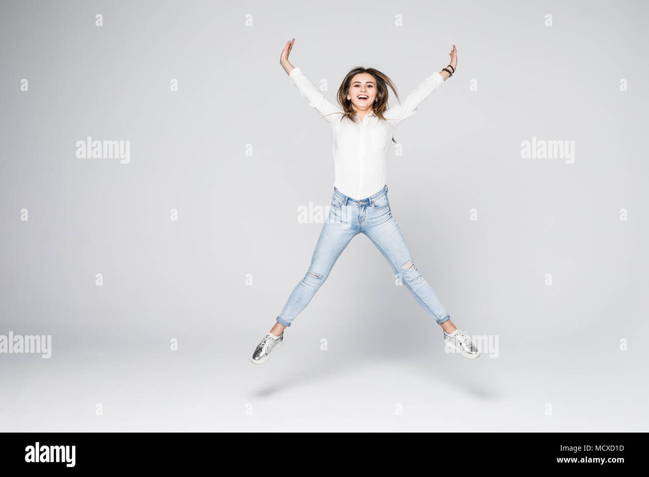 Souriante Jeune Femme Sautant Dans Poing Leve L Air Over White Background Photo Stock Alamy