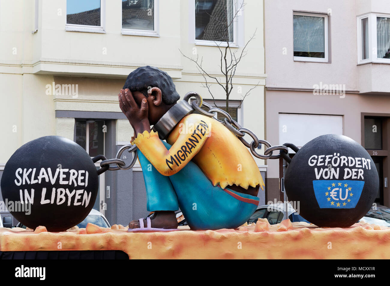 Travailleurs migrants originaires d'Afrique, double chaîne, l'esclavage a parrainé par l'UE, la caricature politique, devise caravane pendant le Carnaval lundi Banque D'Images