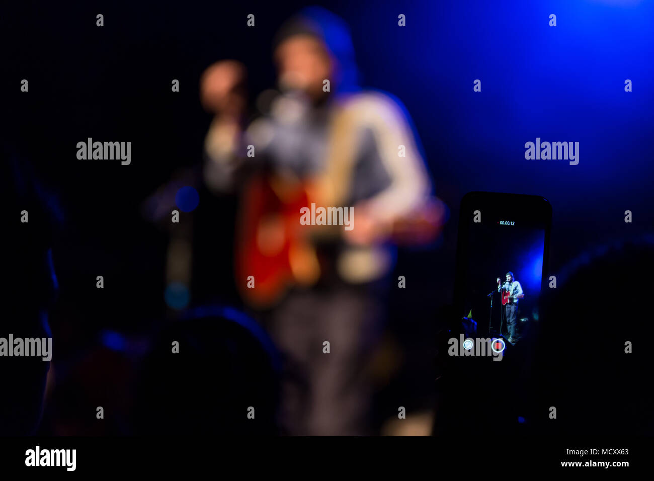 Concertgoer prend une photo avec I-Phone au concert du chanteur et compositeur suisse Sem Thomas vivent au Schüür Banque D'Images