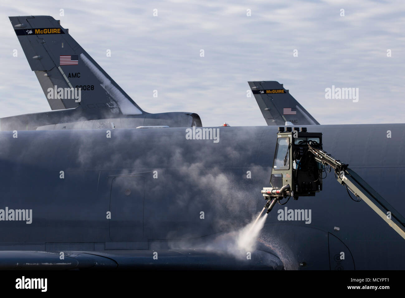 Les aviateurs de l'US Air Force avec le 305e Escadron de maintenance des aéronefs spray liquide de dégivrage sur l'aile d'un KC-10 Extender at Joint Base McGuire-Dix-Lakehurst, N.J., le 3 mars 2018. (U.S. Air Force photo par le Sgt. Mark C. Olsen) Banque D'Images