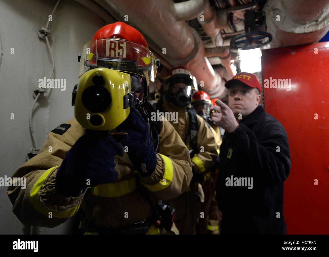 180307-N-NM917-096 Yokosuka, Japon (7 mars 2018) 3e classe Mécanicien Hunter Olson, de North Field, au Wisconsin, utilise un Imageur Thermique Les pompiers de la Marine (NFTI) à vérifier pour les points d'accès au cours d'un exercice d'incendie à bord de l'espace principal USS Blue Ridge (CAC 19). NFTI fonctionnent à l'aide de caméras d'imagerie infrarouge de pénétrer des espaces remplis de fumée afin de localiser le personnel au sol ou obscurci les incendies. Blue Ridge et son équipage ont maintenant entré dans une phase finale de l'entretien et la formation en vue de devenir pleinement capable de mission pour les opérations. (U.S. Photo par marine Spécialiste de la communication de masse 2e classe/KirkJohnson Jordanie Relea Banque D'Images