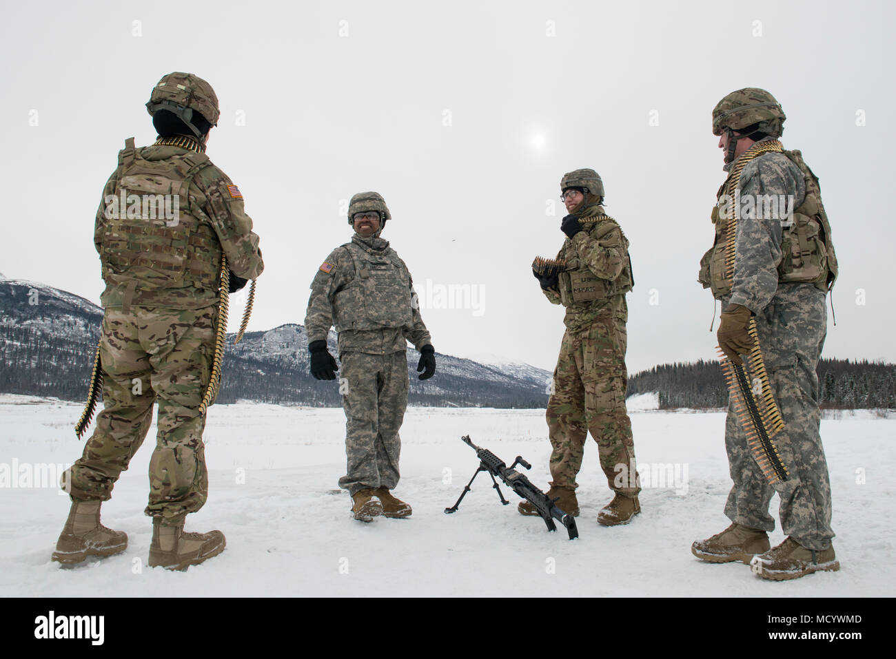 Soldats affectés à la 109e compagnie de transport, 17e Bataillon de soutien au maintien en puissance de combat de l'armée américaine, l'Alaska, partager un moment de légèreté avant de procéder M240B machine gun de tir réel à Joint Base Elmendorf-Richardson, Alaska, le 6 mars 2018. Les soldats de la 17e SCBS a récemment terminé une série d'événements d'entraînement que perfectionné leurs compétences sur une variété de systèmes d'armes utilisés pour la protection au cours de missions de convoi. (U.S. Air Force photo par Alejandro Peña) Banque D'Images
