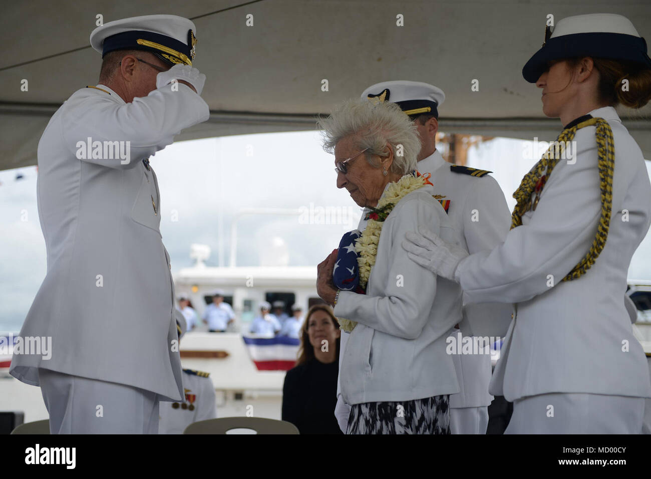 Vice-amiral. Fred Midgette, commandant de la Garde côtière des États-Unis, Région du Pacifique, présente 'tante' Stella Gerczak avec le drapeau américain lors de la cérémonie de mise en service de la U.S. Coast Guard Cutter Joseph Gerczak (WPC-1126) sur la base d'Honolulu, 9 mars 2018. Le drapeau original a été perdu dans une inondation de la famille il y a des années et a été remplacé après avoir atterri sur le United States Capitol et derrière le Gerczak Joseph. (U.S. Photo de la Garde côtière canadienne par le maître de 3e classe Amanda Levasseur/libérés) Banque D'Images