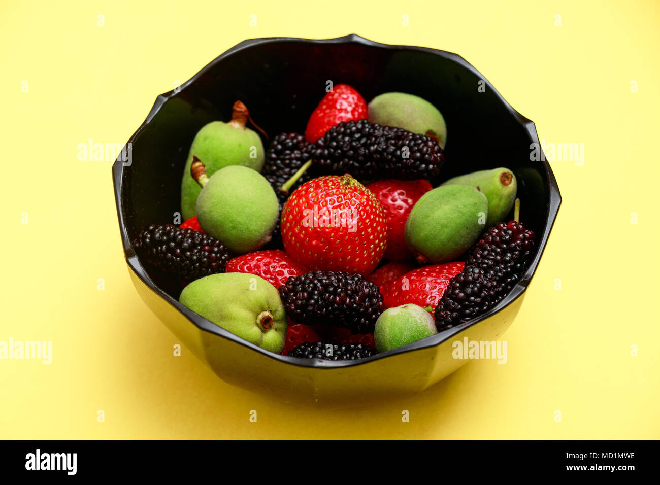 Délicieux avec les fruits d'été sur un fond jaune frais mise à plat. Cerise, mûre, fraise dans une assiette de service. Haut de la vue plate Banque D'Images