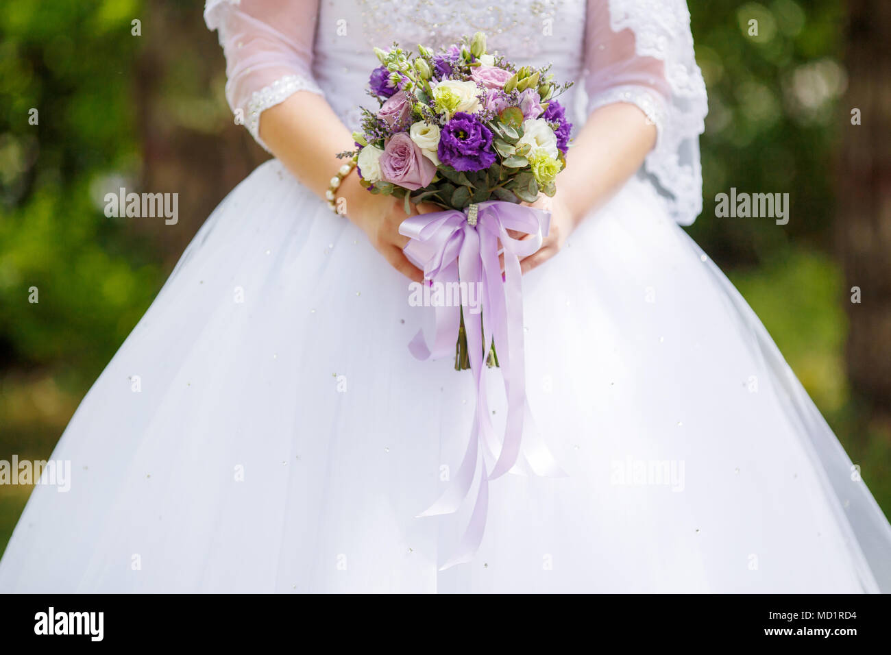 Mariée en robe blanche holding purple bouquet de mariage en mains, libre. Concept de mariage Banque D'Images Mariée en robe blanche holding purple bouquet de mariage en mains, libre. Concept de mariage Banque D'Images