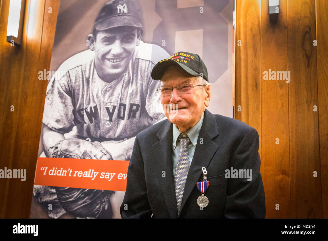 Ancien combattant de la Seconde Guerre mondiale William G. Easton pose devant un portrait de New York Yankees catcher Yogi Berra après le New Jersey Department de l'armée et des Affaires des anciens combattants cérémonie des médailles de l'état au Yogi Berra Musée & Centre d'apprentissage, peu tombe, N.J., le 27 mars 2018. Matelot de 2e classe Lawrence Peter Berra a servi dans la marine des États-Unis pendant la Seconde Guerre mondiale, et a participé au débarquement de Normandie. Banque D'Images