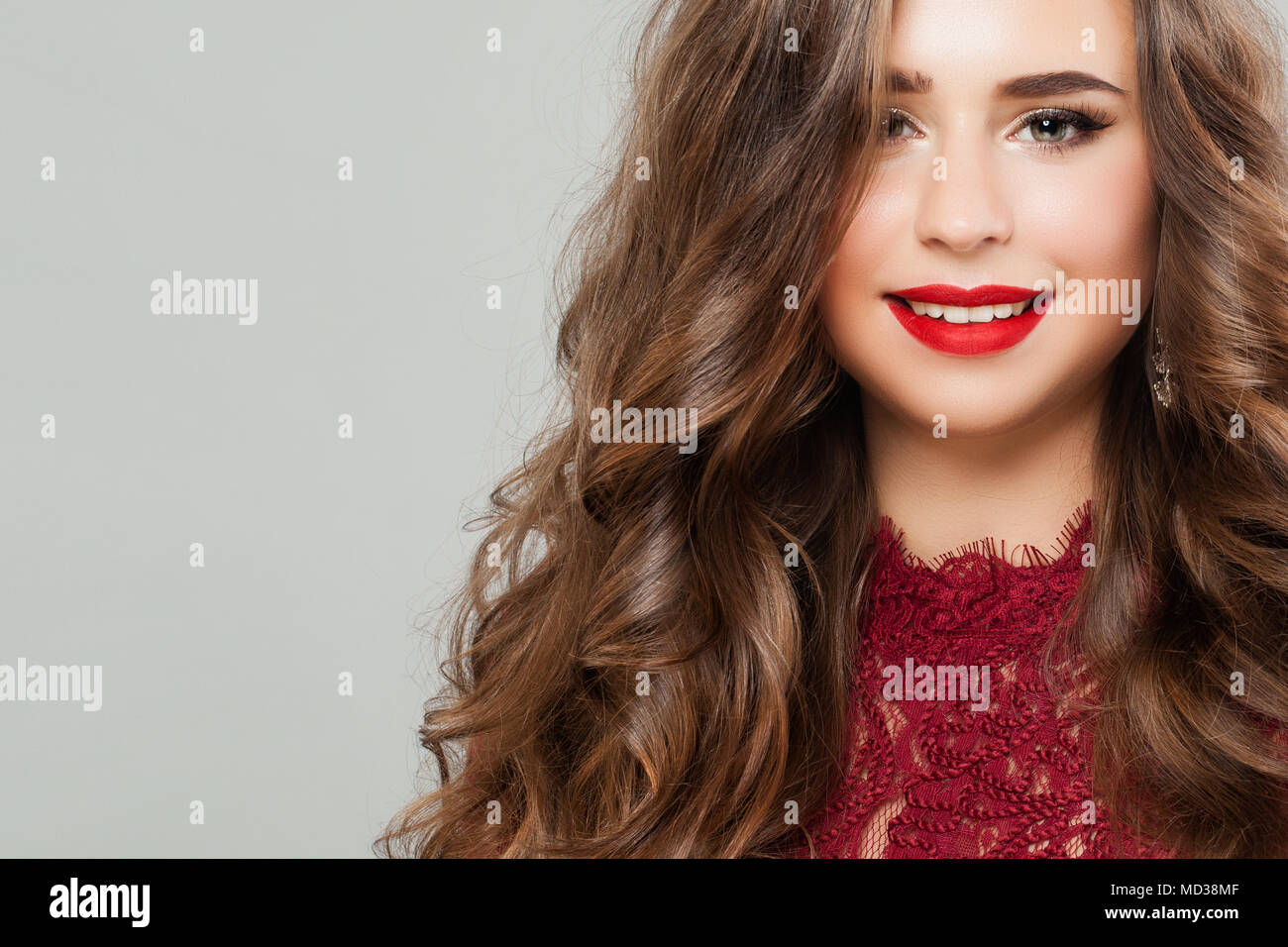 Jeune femme avec des longs cheveux permanentés. Portrait of Cute Smiling Girl Fashion model with Red Lips Makeup Banque D'Images