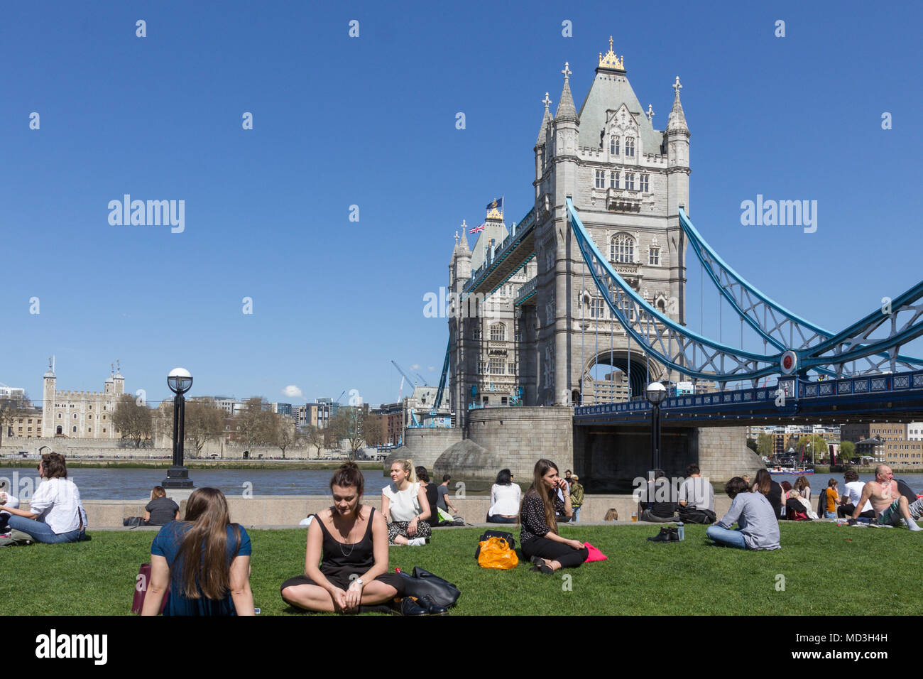 Londres, Royaume-Uni. 18 avr, 2018. Les personnes bénéficiant du soleil le long de la rivière Thames, avec le Tower Bridge en arrière-plan, sur l'un des jours les plus chauds de l'année jusqu'à présent. Le beau temps est prévu pour durer pour le reste de la semaine. Credit : Milton Cogheil/Alamy Live News Banque D'Images