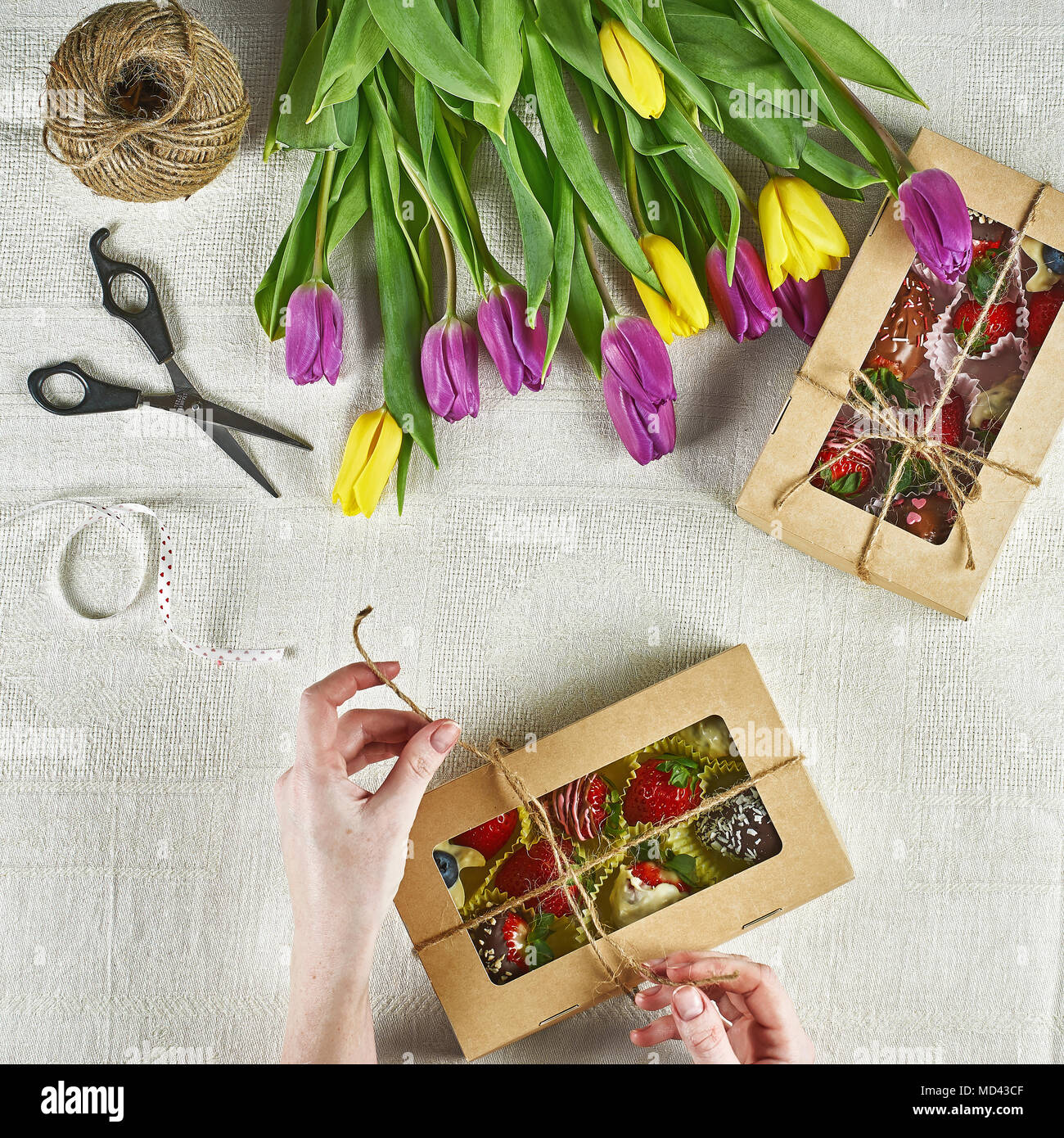 Cadeaux faits main comestibles, les fraises dans le chocolat, macaron,  décoré avec des tulipes dans une boîte-cadeau Photo Stock - Alamy