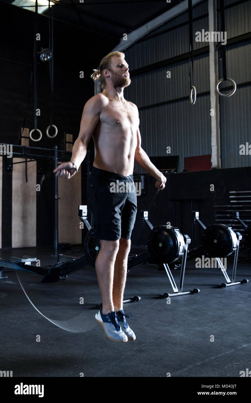 L'exercice de l'homme dans un gymnase, avec corde à sauter de vitesse Banque D'Images
