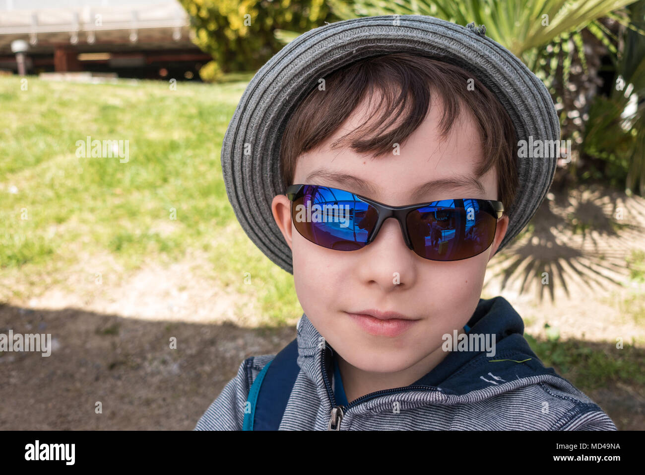 Un jeune garçon portant des lunettes pose pour une photo. Banque D'Images