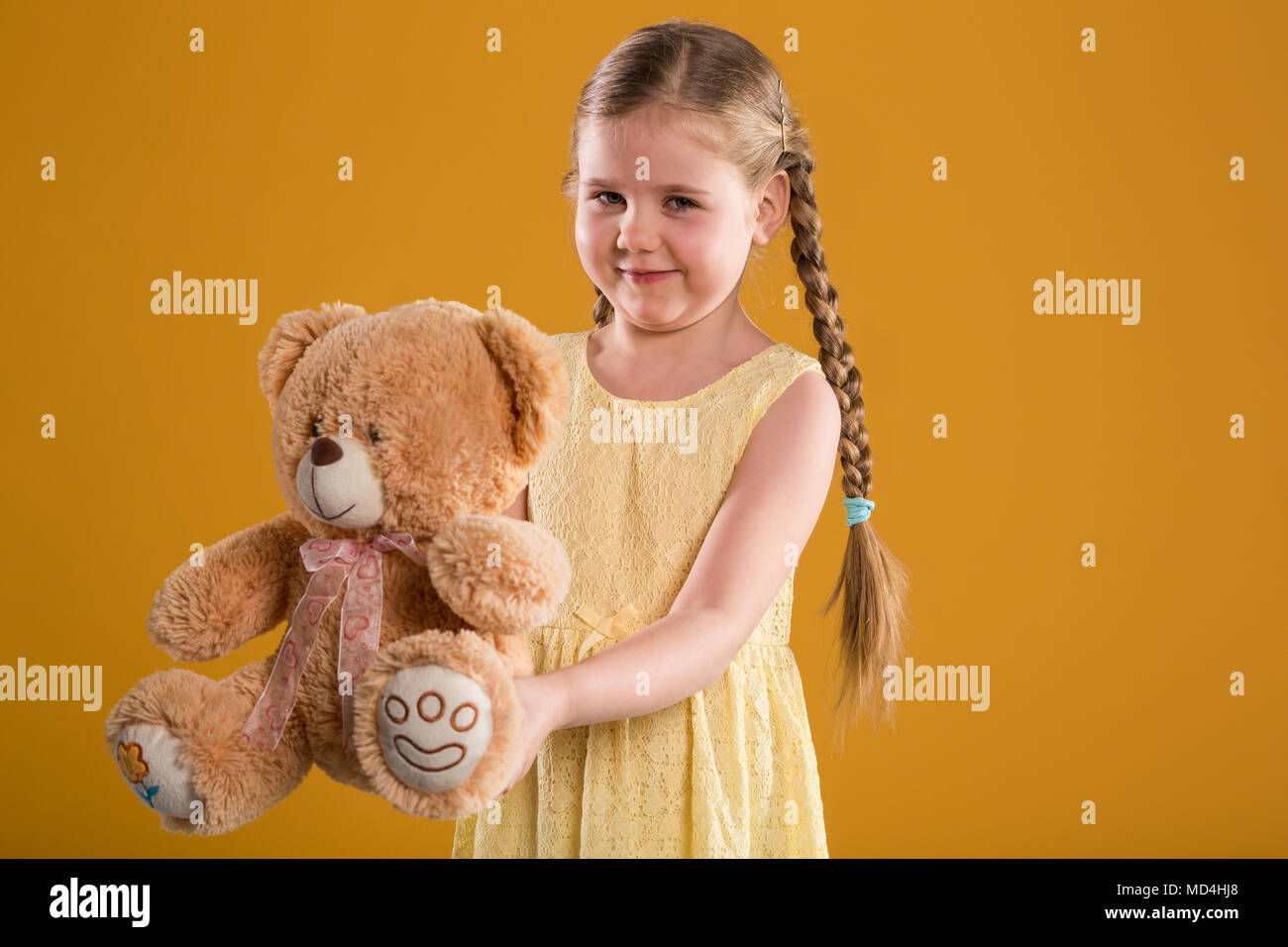 Portrait de jeune fille en robe jaune happy teddy bear Banque D'Images