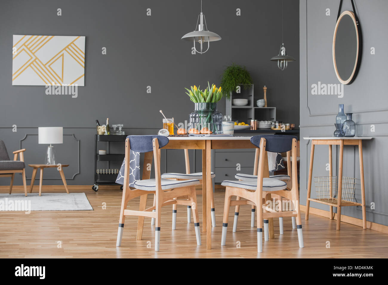 Appartement gris élégant intérieur avec planchers de bois, moulures et une salle à manger ouverte et salon avec des meubles en bois Banque D'Images