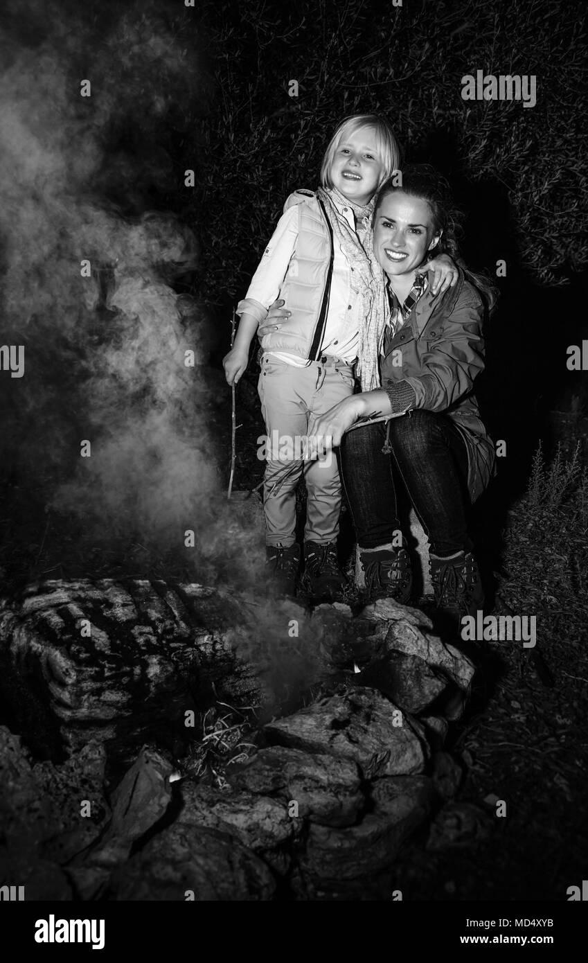 Dans la nature. bonne mère et fille d'un feu de camp près de voyageurs Banque D'Images