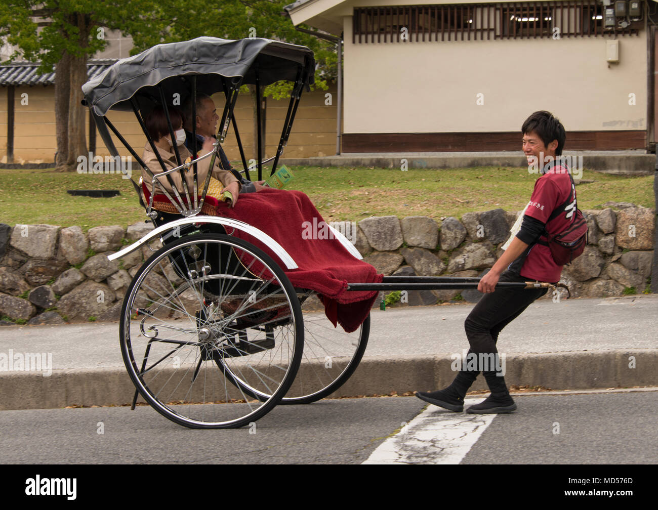 Rickshaw étant tiré vers le haut de la pente à Nara, au Japon. Banque D'Images