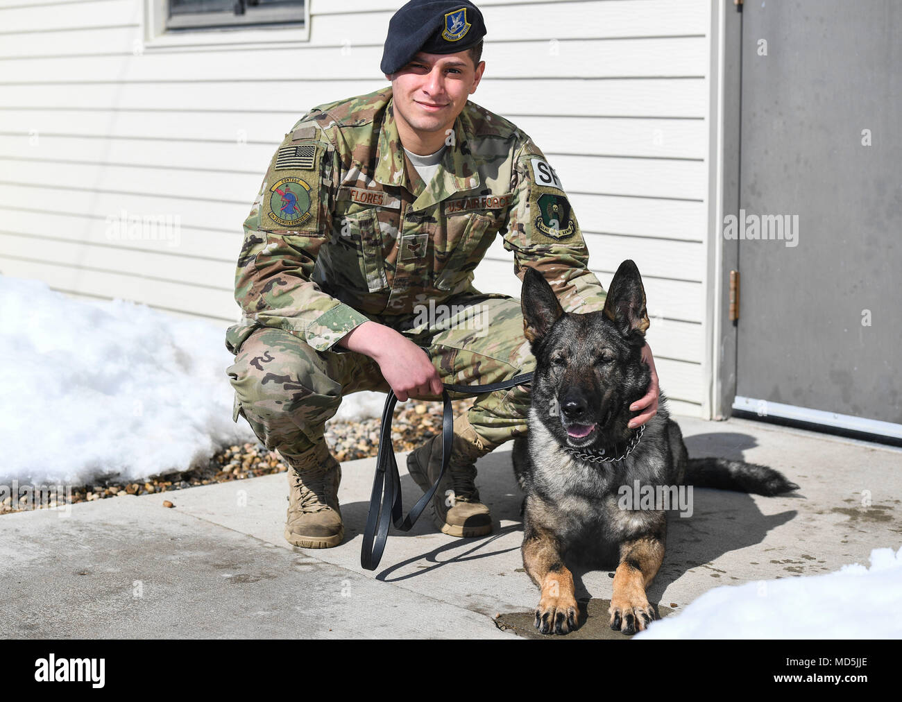 Airman Senior Angel Flores, 5e Escadron des Forces de sécurité de chien de travail militaire, s'agenouille à côté de son partenaire, Kety, MWD à Minot Air Force Base, N.D., le 13 mars 2018. L'utilisation de chiens de travail militaire des chiens spécialement dressés pour assurer la sécurité des bases militaires et de personnel. (U.S. Air Force photo par un membre de la 1re classe Jonathan McElderry) Banque D'Images