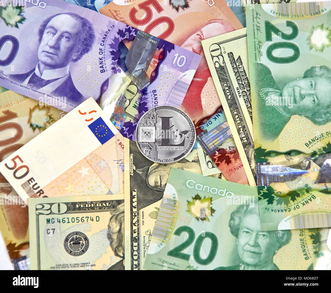 Montréal, Canada - le 10 mars 2018 : Litecoin cryptocurrency pièce d'argent et le logo sur l'euro, les dollars américains et les dollars canadiens. Banque D'Images