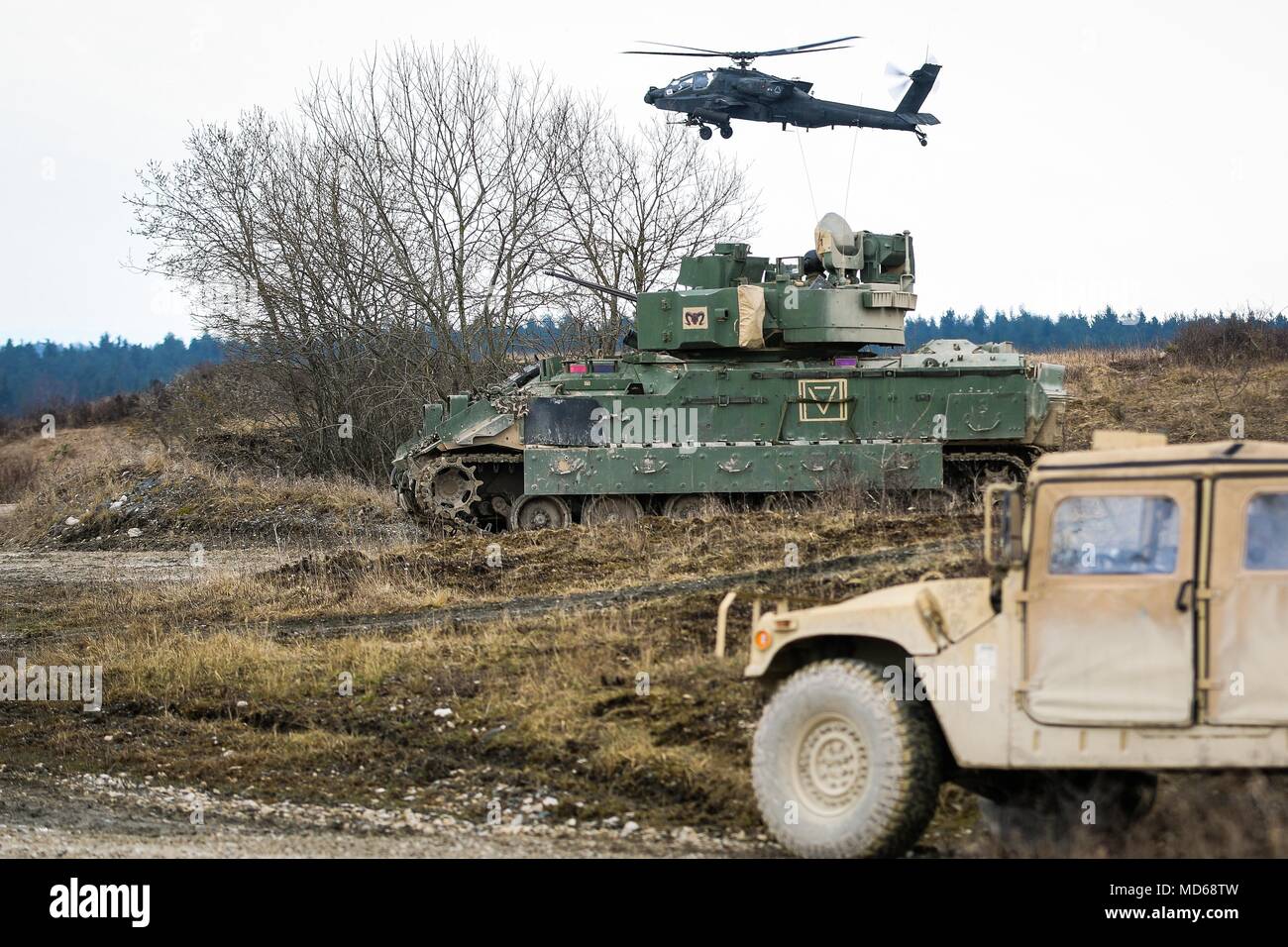 Un hélicoptère Apache AH-64 avec 1er Bataillon, 3e Régiment d'aviation, 12e Brigade d'aviation de combat, un véhicule de combat Bradley M2 et Humvee avec 5e Escadron, 4e régiment de cavalerie blindée, 2e Brigade Combat Team, 1re Division d'infanterie, tenter de se doter d'une région au cours d'un exercice de tir réel interarmes (CALFEX) à Grafenwoehr Domaine de formation, l'Allemagne, Mai 28, 2018. (U.S. Photo de l'armée par la CPS. Hubert D. Delany III / 22e Détachement des affaires publiques mobiles) Banque D'Images